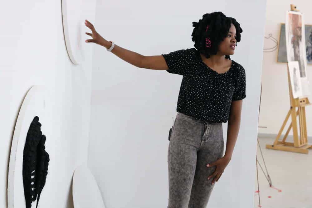 Lebohang Motaung explaining her work during a studio visit. Courtesy of The Project Space.
